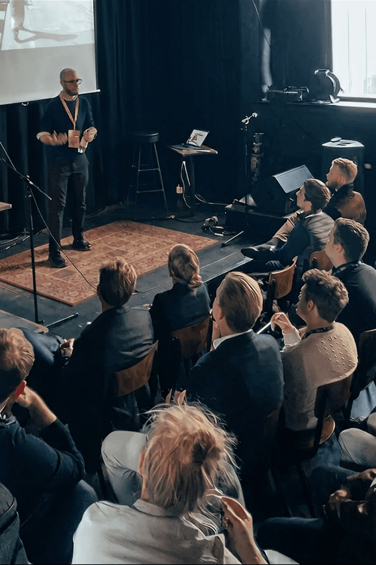 Sebastian presenting on stage to a seated audience