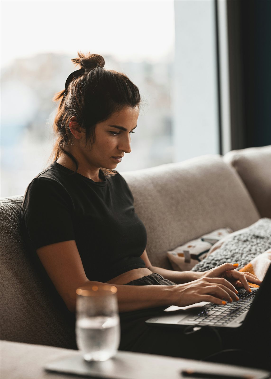 A person focused on a laptop at home - the kind of everyday user who has to trust an online identity check